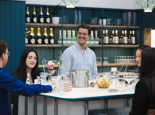 Inside a Lind and Lime gin tour as the guide tells the story of the company to those sitting on bar stools. 